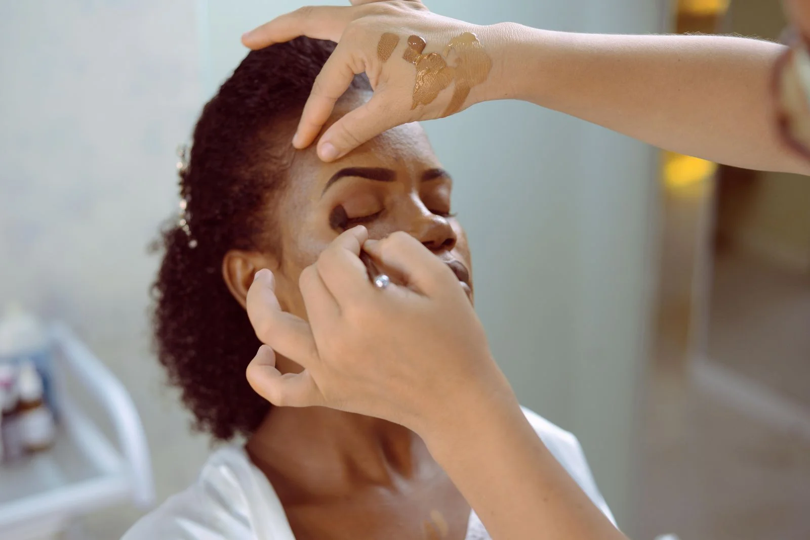 A makeup artist applying eyeshadow during a beauty appointment